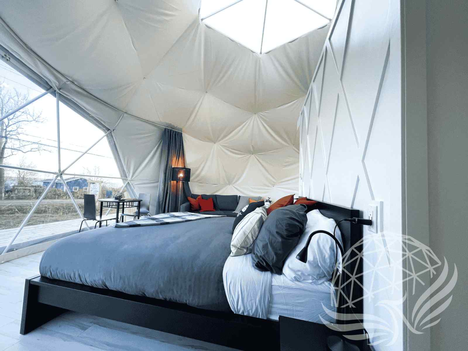 Airy dome bedroom with mid-century furniture and forest backdrop