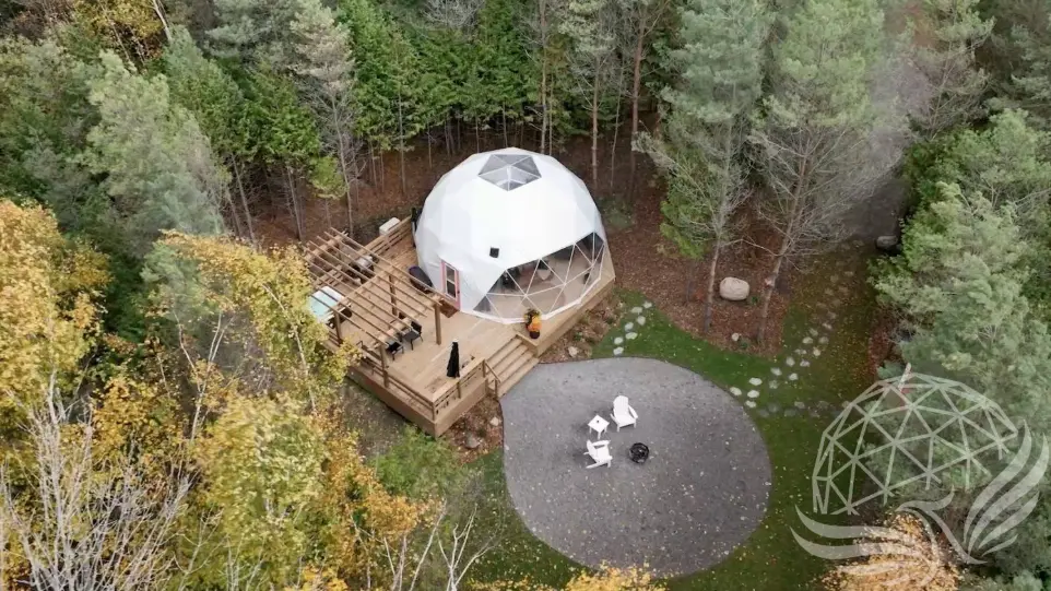 White geodesic dome in the middle of the woods
