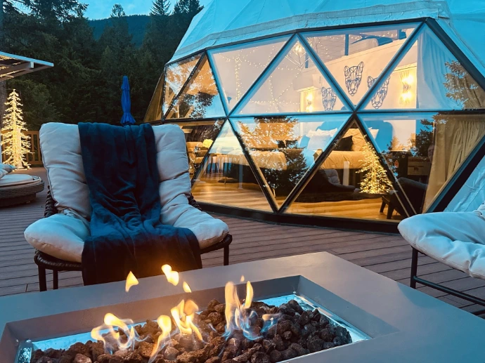 Glass panorama window on a geodesic dome with firepit outside