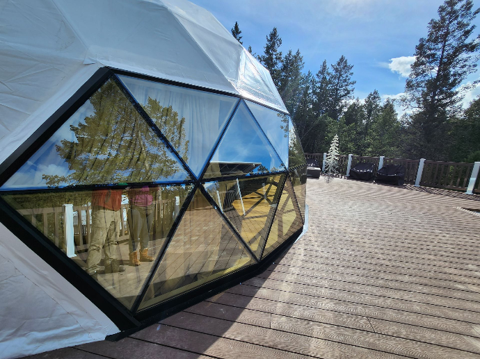 White geodesic dome with glass window on wooden deck