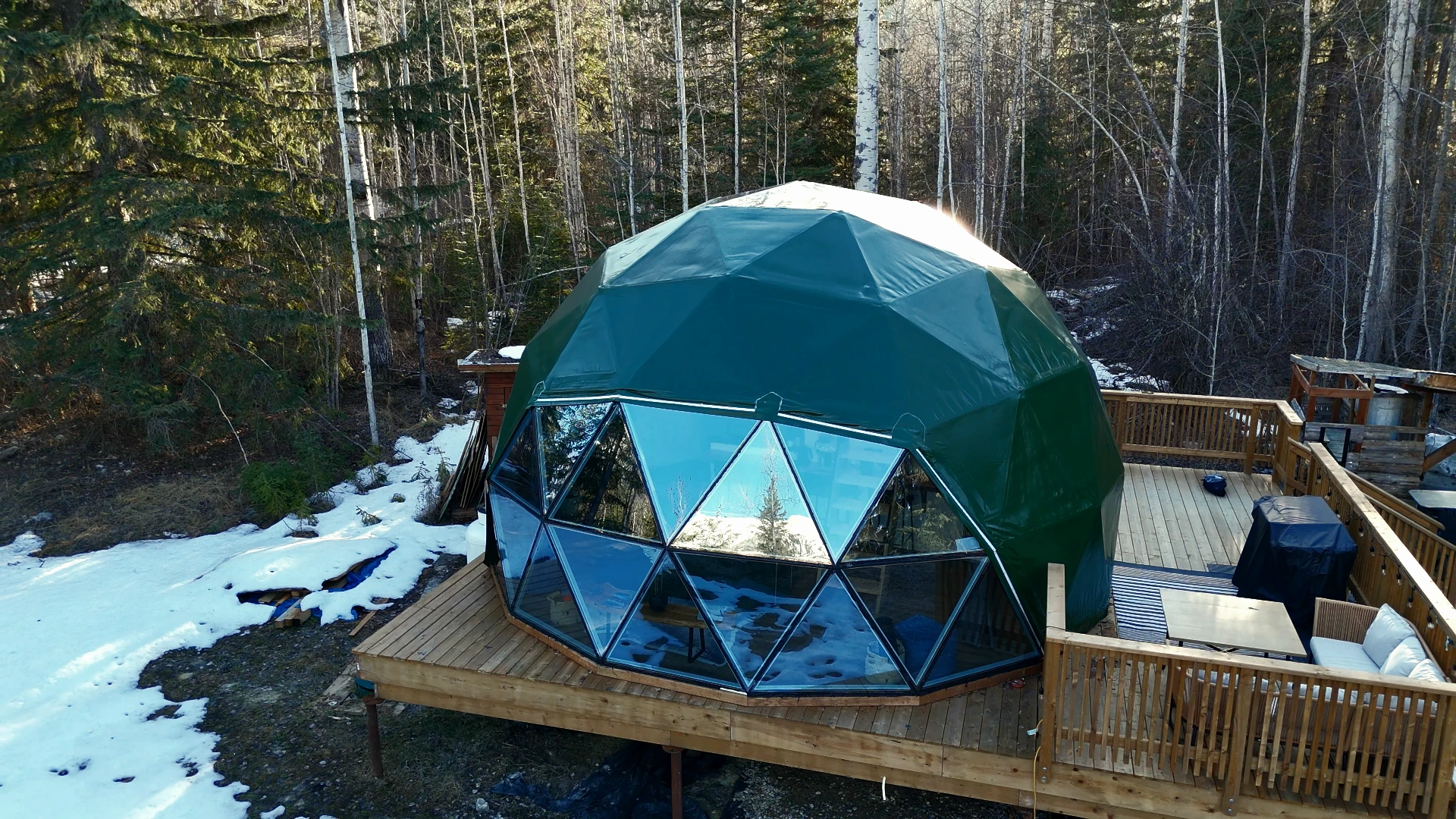 Forest green dome with wooden deck in the woods