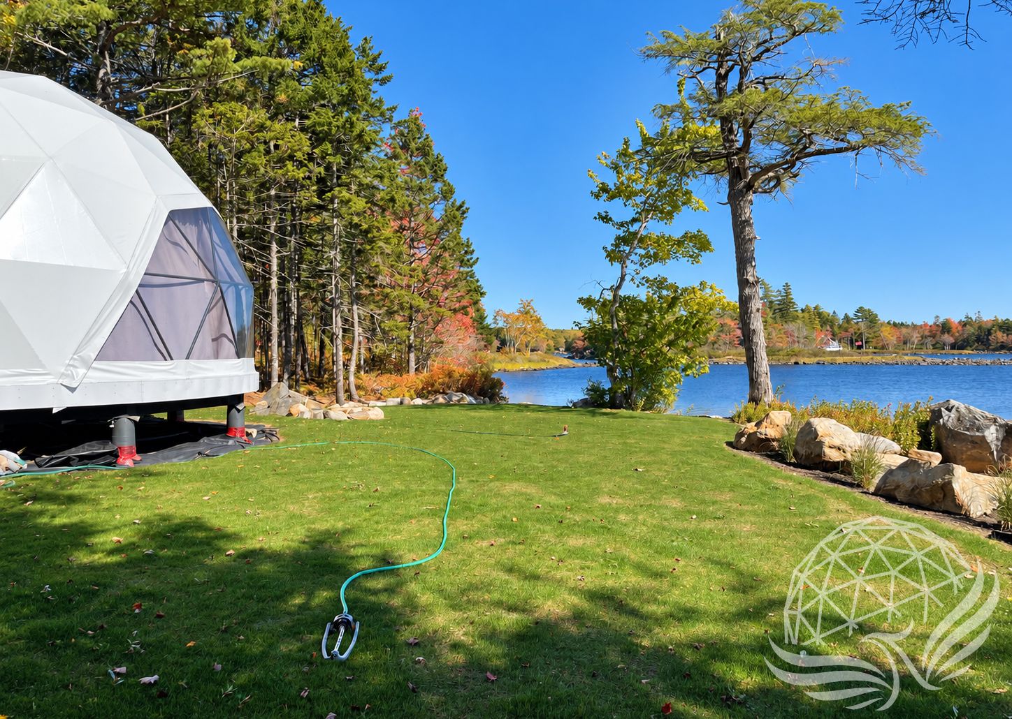 White Geodesic dome exterior overlooking a lake